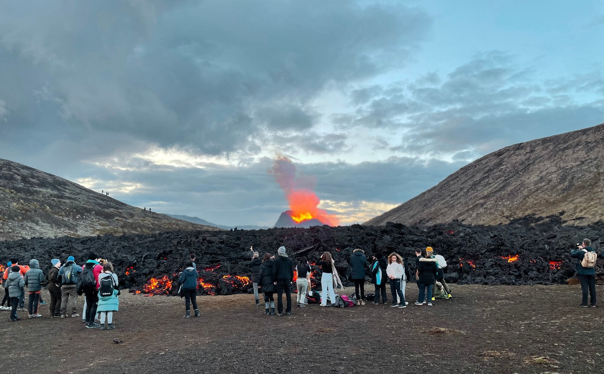 People standing around a volcano eruption